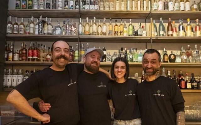 Il team di Cactus Joe dietro il bancone dell'agaveria di Milano, tra bottiglie di tequila e mezcal